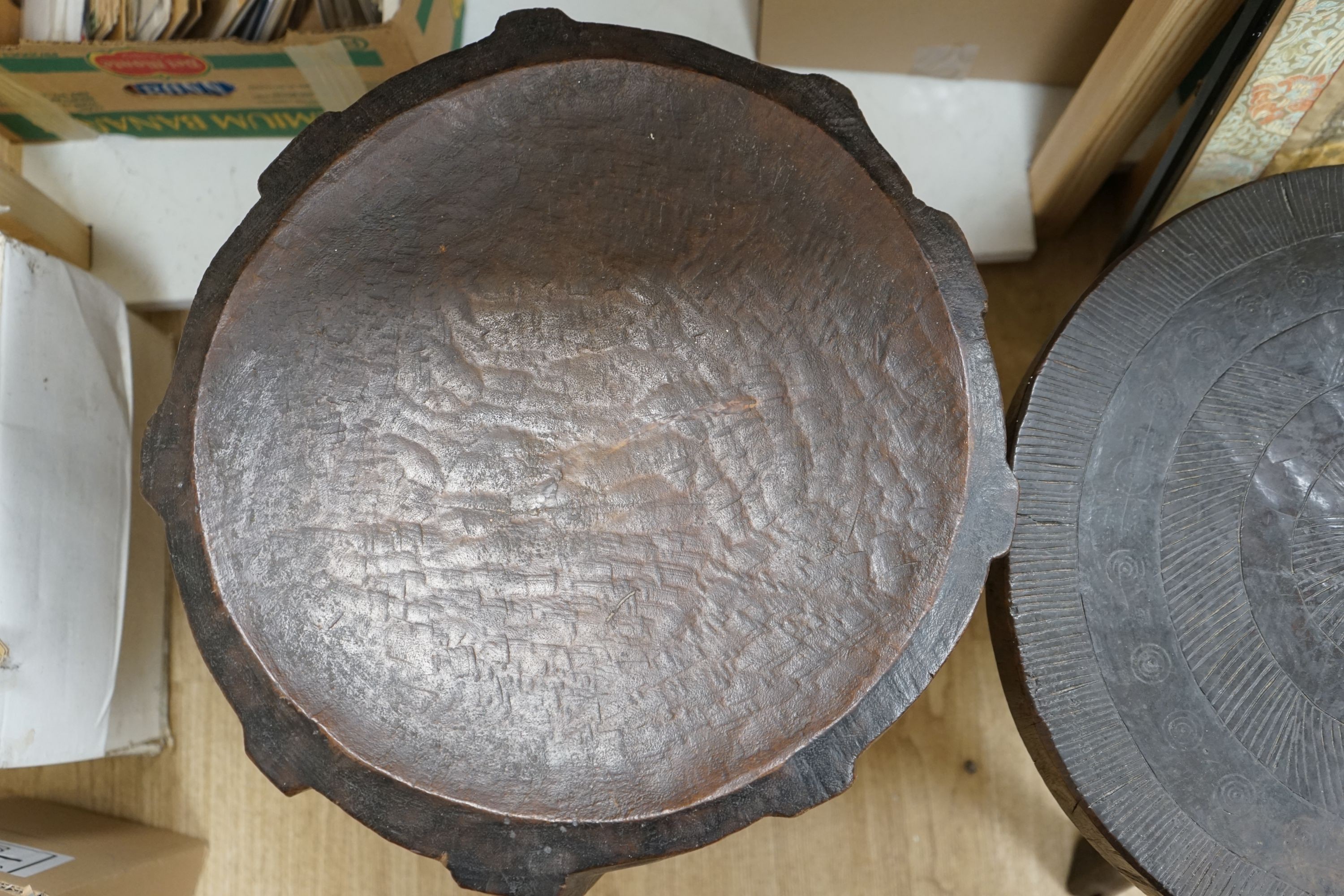 Two African circular carved hardwood low tables, larger 46cm diameter, height 50cm
